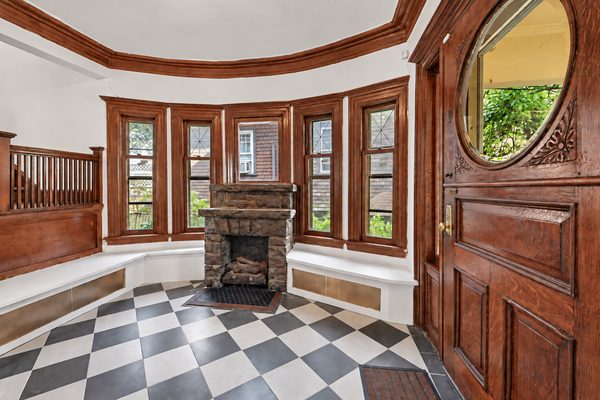 The first of six fireplaces, in the foyer, with built-in window seats either side