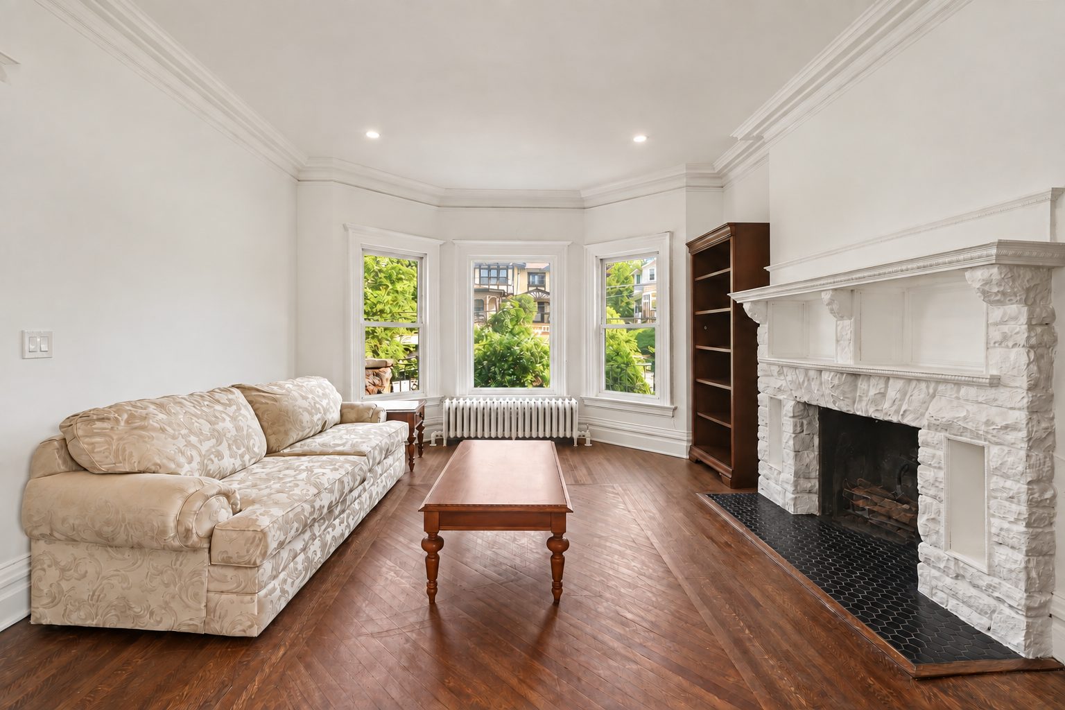 The living room's stone fireplace in a wide format, flanked by built-in bookcases