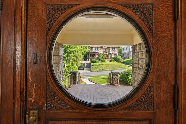 The circular looking glass in the front door, framing the porch and the street